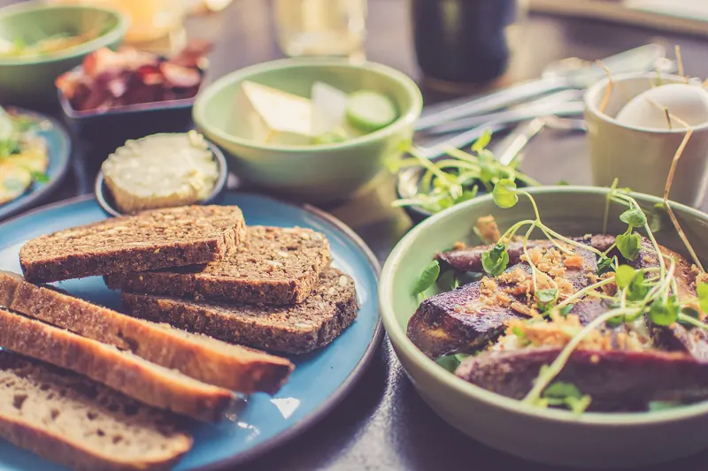 Gedeckter Tisch mit Brot, Salat und gefüllten Schalen